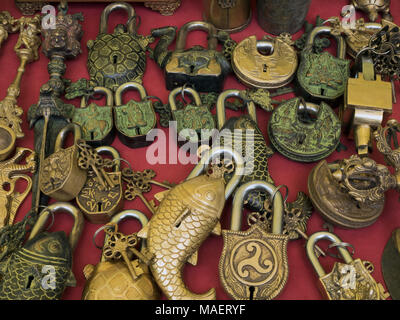 Ancien antiquité vintage handmade : serrures serrures métalliques avec des clés sous la forme d'animaux, de poissons, de tortues sur un fond rouge, artisan traditionnel népalais Banque D'Images