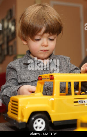 Montréal,Canada,31,mars,2018.jeune garçon de 3 ans à l'intérieur avec un jouet school bus.Credit:Mario Beauregard/Alamy Live News Banque D'Images