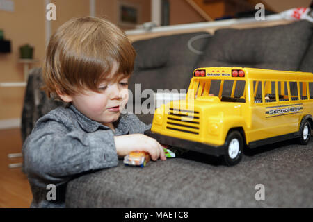 Montréal,Canada,31,mars,2018.jeune garçon de 3 ans à l'intérieur avec un jouet school bus.Credit:Mario Beauregard/Alamy Live News Banque D'Images