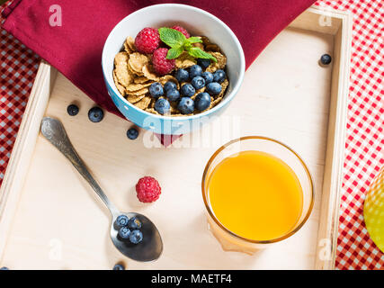 Complet avec céréales multigrains sain aux petits fruits et un verre de jus pour le petit déjeuner. Banque D'Images