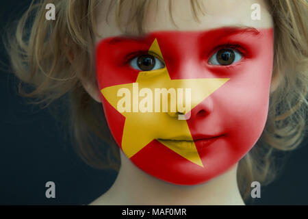 Portrait d'un enfant avec un drapeau vietnamien peint Banque D'Images