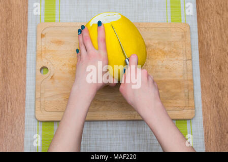 Girl cleaning ses mains avec agrumes pomelo, sur une planche en bois Banque D'Images