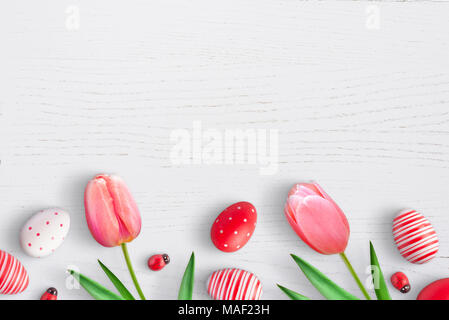 Œufs de Pâques et printemps tulipe fleurs sur la surface en bois blanc. Espace libre pour le texte. Vue d'en haut. Banque D'Images