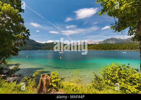 Vue sur le lac d'Eibsee Garmisch-Partenkirchen, Allemagne en été à une chaîne de montagnes lointaines avec un ferry touristique sur l'eau. Banque D'Images