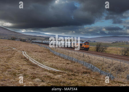 Gb Railfreight class 66 locomotive au Armoy, s'installer à carlisle railway avec un train de marchandises transportant des ensembles dans Arcow carrière près de régler Banque D'Images