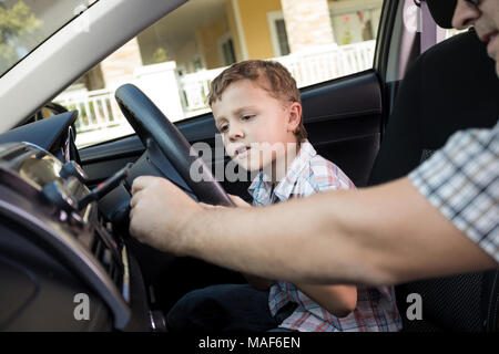 Heureux père et fils assis dans la voiture à la journée. Les gens se préparer pour road trip. Concept de famille heureuse. Banque D'Images