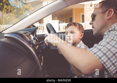 Heureux père et fils assis dans la voiture à la journée. Les gens se préparer pour road trip. Concept de famille heureuse. Banque D'Images
