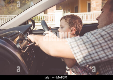 Heureux père et fils assis dans la voiture à la journée. Les gens se préparer pour road trip. Concept de famille heureuse. Banque D'Images