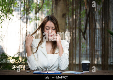 Young businesswoman stretching elle-même et de bâiller au travail, à l'état prêt pour travailler. Banque D'Images