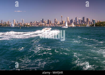 Un bateau se dirige vers le ciel du centre-ville de Sydney et privés yacths naviguant dans le port de Sydney, Australie Banque D'Images