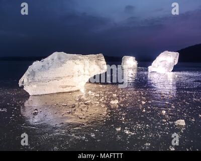 Vue détaillée dans une glace avec des rayures profondes et des fissures. Couper contre floe à ciel du soir et projecteur. Banque D'Images