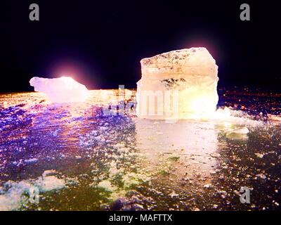 Vue détaillée dans une glace avec des rayures profondes et des fissures. Couper contre floe à ciel du soir et projecteur. Banque D'Images