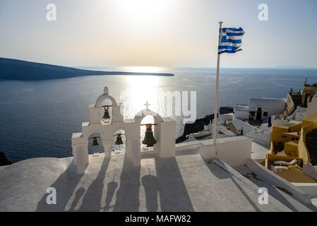 Clochers et le drapeau grec sur la mer à Santorin Banque D'Images