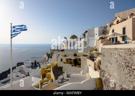 Un drapeau grec souffle dans le vent à Oia à Santorin Banque D'Images