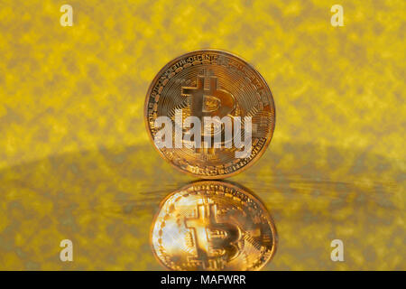 Crypto Bitcoin or monnaie sur un jaune. Banque D'Images