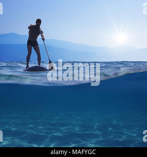 Stand Up Paddle. Jeune homme flottant sur un bord sup. Sous-vue de mer, l'espace de copie pour le texte Banque D'Images