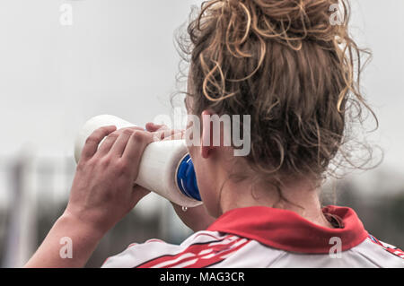 Un joueur de soccer féminin boire d'une bouteille en plastique blanc Banque D'Images