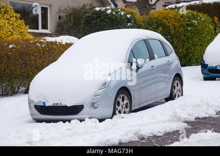 Une voiture dans le fifre d'une couverture de neige sur le pare-brise et le capot. Banque D'Images