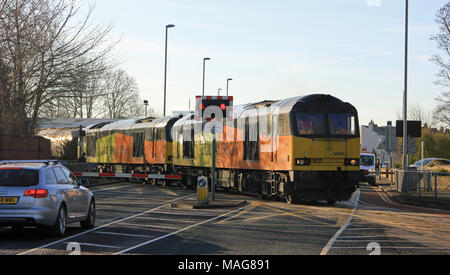La locomotive diesel Colas deux arrêter le trafic qu'ils franchissent Strand Road à Preston avec un train de citernes de bitume par un beau matin de printemps. Banque D'Images