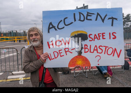 Aldermaston, au Royaume-Uni. 1er avril 2018. Un militant soutient une grande affiche avec le message 'Accident - Comment est-il sûr de Alder-Blaston' peint spécialement pour la CND célébration du 60ème anniversaire de la première marche qui a mobilisé des milliers d'Aldermaston contre la bombe et en forme de protestation radicale pendant des générations. Leur protestation devant l'Atomic Weapons Establishment inclus un géant, symbole emblématique de la paix, des discours, y compris par certains de ceux sur l'original de mars, le chant et la percussion et a célébré le traité des Nations Unies interdisant les armes nucléaires. Crédit : Peter Marshall/Alamy Live News Banque D'Images