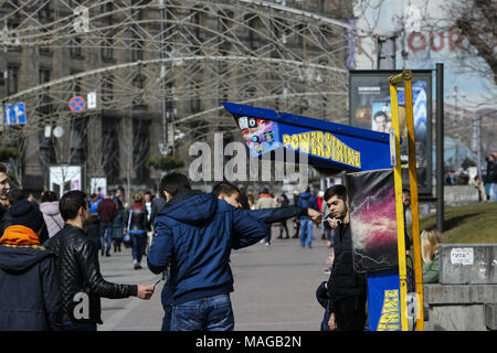 Kiev, Ukraine. 1er avril 2018. Les jeunes vérifier leur force avec une machine de boxe rue payé à la rue Khreshchatyk comme le premier ressort est chaud, à Kiev, Ukraine, le 1 avril 2018. Credit : Sergii Kharchenko/ZUMA/Alamy Fil Live News Banque D'Images