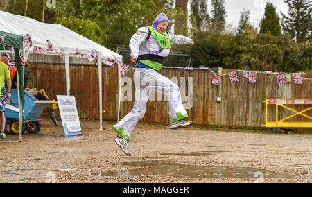 Bolney Sussex UK 2 Avril 2018 - Simon Cowen habillé en Buzz Lightyear bondit à travers une flaque à la course annuelle de la PRAM Bolney aujourd'hui qui a lieu dans les huit cloches pub dans le village tous les Easter Bank Holiday lundi la collecte de fonds pour les organismes de bienfaisance locaux SERV Sussex et l'âge UK Photographie prise par Simon Dack Crédit : Simon Dack/Alamy Live News Banque D'Images