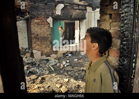 L'Inde, d'Anantnag. 2ème apr 2018. Un jeune garçon regarde une maison endommagée après une fusillade dans dailgam village de South district du Cachemire : Crédit d'Anantnag ZAFAR DAR/Alamy Live News Banque D'Images