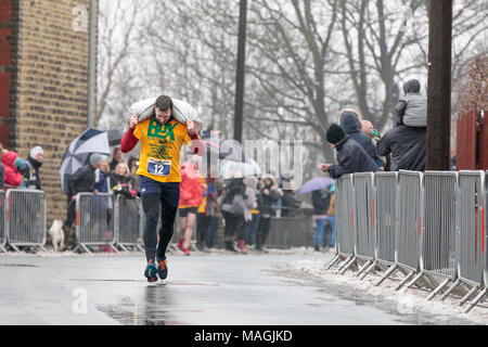 Gawthorpe, West Yorkshire, Royaume-Uni. Le 02 avril 2018. Vainqueur de la première des deux courses pour hommes s'approche de la ligne d'arrivée. Championnats du monde de l'exécution du charbon ont lieu chaque année le lundi de Pâques, lorsque les concurrents, portent des sacs de charbon, de race sur une piste en montée 1012 m à travers l'ancien village minier près de Wakefield. Les concurrents masculins portent des sacs de 50kg et les femelles 20kg. Les femmes gagnant a été Danielle Sidebottom, Men's gagnant a été Andrew Corrigan. © Ian Wray/Alamy live news Banque D'Images