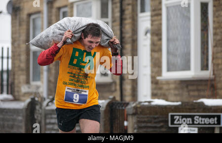 Gawthorpe, West Yorkshire, Royaume-Uni. Le 02 avril 2018. Gagnant de la seconde de 2 courses hommes s'approche de la ligne d'arrivée. Championnats du monde de l'exécution du charbon ont lieu chaque année le lundi de Pâques, lorsque les concurrents, portent des sacs de charbon, de race sur une piste en montée 1012 m à travers l'ancien village minier près de Wakefield. Les concurrents masculins portent des sacs de 50kg et les femelles 20kg. Les femmes gagnant a été Danielle Sidebottom, Men's gagnant a été Andrew Corrigan. © Ian Wray/Alamy live news Banque D'Images