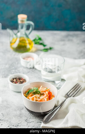 Salade de chou avec carottes, tomates et concombres dans une petite pial sur une table lumineuse. Coleslaw traditionnel Banque D'Images