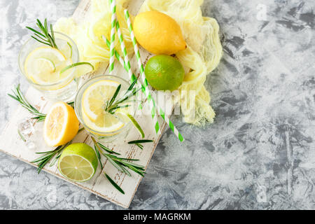 Boisson alcoolisée avec citron et rosemain, dans les verres sur une table lumineuse. Vue de dessus, la place pour le texte Banque D'Images