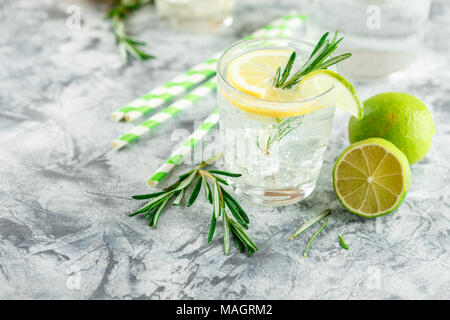 Cocktail sans alcool froid limonade ou avec du citron, du romarin et de la glace dans des verres en verre sur un fond clair Banque D'Images