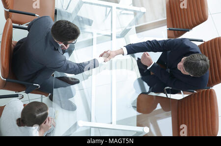 Poignée de l'autre côté de la table. Rencontre autour d'une table de conférence. Banque D'Images