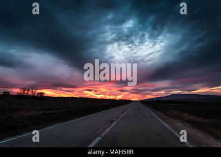 Tout droit à une autoroute près de sunset fiery dramatique crépuscule Banque D'Images