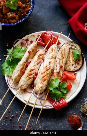 Brochette de poulet arabe, Adana kebab ou sish kebab servi avec des aubergines, poivrons grillés, le persil et l'oignon. Vue de dessus, selective focus Banque D'Images