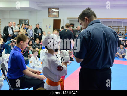 La compétition entre les enfants dans le karaté kumité,.L'entraîneur met en place son élève, un garçon de 8-9 ans pour la première victoire en kumite Kyokushin Karaté Banque D'Images