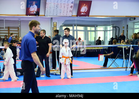 La compétition entre les enfants dans le karaté kumité,.L'entraîneur met en place son élève, un garçon de 8-9 ans pour la première victoire en kumite Kyokushin Karaté Banque D'Images