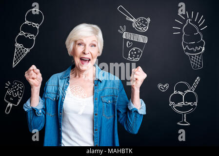 Femme excitée se sentir heureux tout en choisissant la crème glacée dans un café Banque D'Images