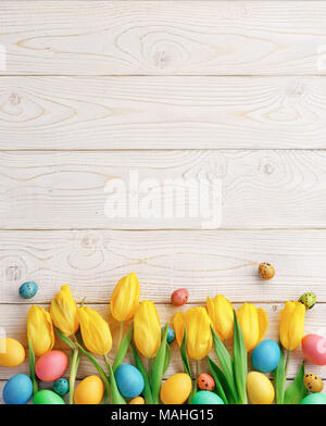 Arrière-plan de Pâques avec des œufs de Pâques et de fleurs de printemps. Vue de dessus avec l'exemplaire de l'espace. Banque D'Images