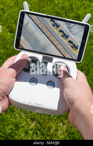 Mains tenant Drone Quadcopter Contrôleur avec passage de tracteurs à l'écran. Banque D'Images