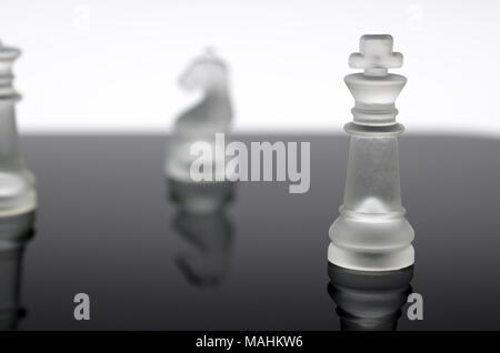 Il s'agit d'une pièce d'échecs, un roi translucide qui se distingue parmi les autres pièces qui sont volontairement floues. Banque D'Images