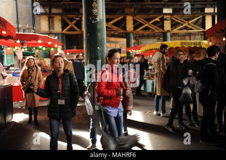 Un pigeon vole d'anciens visiteurs et touristes à Borough Market à Londres, Angleterre Banque D'Images