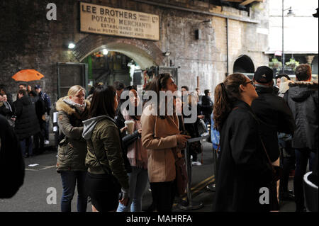 Les touristes et les visiteurs d'attente pour commander de la nourriture de poissons à Borough Market à Londres, Angleterre Banque D'Images