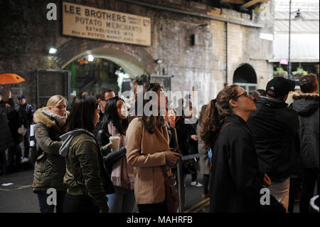 Les touristes et les visiteurs d'attente pour commander de la nourriture de poissons à Borough Market à Londres, Angleterre Banque D'Images