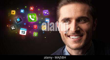 Portrait of a young businessman with applications colorées à côté de lui sur un fond sombre Banque D'Images