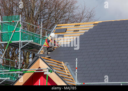 Carreleur Toiture tuiles raccord le long des bords du toit sur une nouvelle construction House UK Banque D'Images