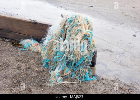 Les déchets en plastique dans la mer demeure de jeter les filets de pêche et des cordages échoués sur tp un épi sur la côte de la mer du Nord. Banque D'Images