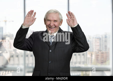 Caucasian business man est en train de rire avec les mains. Extrêmement heureux homme en costume. Avec Windows backgorund ville industrielle. Banque D'Images