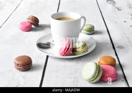 Délicieux macarons ou Biscuits macaron et tasse à café. Pause café scène avec ses macarons colorés et tableau blanc. Banque D'Images