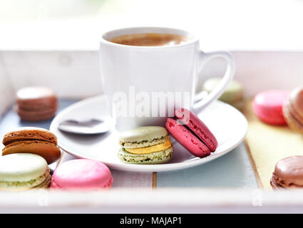 Délicieux macarons ou Biscuits macaron et tasse à café. Pause café scène avec ses macarons colorés et tableau blanc. Banque D'Images